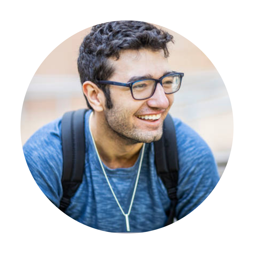 Tânăr cu ochelari și tricou albastru zâmbind.